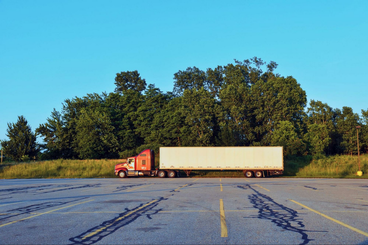 a semi truck and trailer in a parking lot, as featured in The Wine Movers’ blog on professional wine movers and moving a wine collection